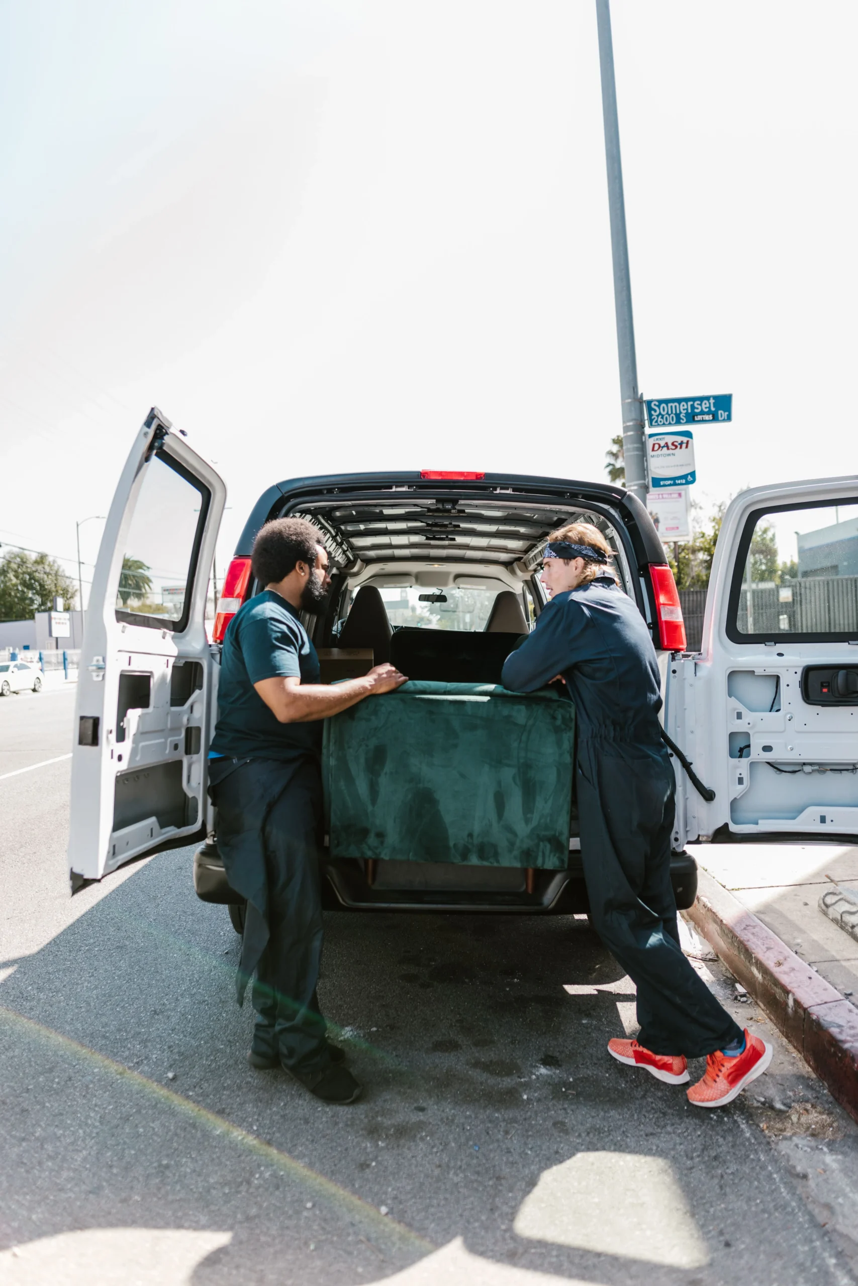 Movers loading a couch into a van for furniture removal quotes in London Ontario